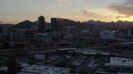 5.7K aerial stock footage fly low by railroad tracks with view of high-rise office towers, and setting sun in Downtown Tucson, Arizona Aerial Stock Footage | DX0002_146_036