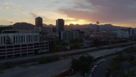 5.7K aerial stock footage fly low by railroad tracks and away from high-rise office towers, and setting sun in Downtown Tucson, Arizona Aerial Stock Footage | DX0002_146_037