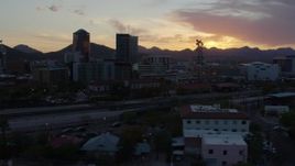 5.7K aerial stock footage pass railroad tracks while focused on high-rise office towers at sunset in Downtown Tucson, Arizona Aerial Stock Footage | DX0002_146_044