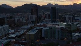 5.7K aerial stock footage reverse view of office towers at sunset with mountains in distance, Downtown Tucson, Arizona Aerial Stock Footage | DX0002_147_010