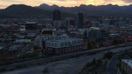 5.7K aerial stock footage flyby office towers at sunset with mountains in distance, Downtown Tucson, Arizona Aerial Stock Footage | DX0002_147_011