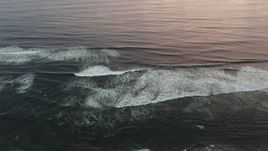 4K aerial stock footage of flying away from ocean waves to reveal the beach at sunset, Long Beach, Washington Aerial Stock Footage | DX0002_148_025