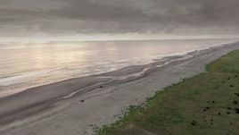 4K aerial stock footage approach the beach at sunset, pan across the ocean in Long Beach, Washington Aerial Stock Footage | DX0002_148_034