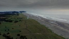 4K aerial stock footage of the beach as fireworks go off at sunset in Long Beach, Washington Aerial Stock Footage | DX0002_148_037