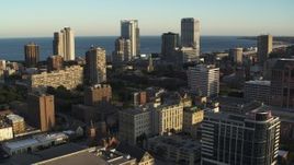 5.7K aerial stock footage of flying by the skyline seen from college campus at sunset in Downtown Milwaukee, Wisconsin Aerial Stock Footage | DX0002_150_017