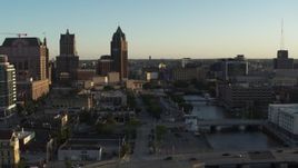 5.7K aerial stock footage tall office tower and city buildings by the Milwaukee River at sunset, Downtown Milwaukee, Wisconsin Aerial Stock Footage | DX0002_150_026