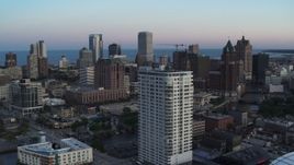 5.7K aerial stock footage descend by apartment complex with view of downtown at twilight, Downtown Milwaukee, Wisconsin Aerial Stock Footage | DX0002_150_030