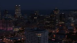 5.7K aerial stock footage of skyscrapers seen while descending by apartment high-rise at night, Downtown Milwaukee, Wisconsin Aerial Stock Footage | DX0002_151_006