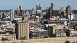 5.7K aerial stock footage of the city's skyline in Downtown Milwaukee, Wisconsin, seen from industrial buildings Aerial Stock Footage | DX0002_152_013