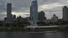 5.7K aerial stock footage descend by skyscrapers to reveal the art museum by Lake Michigan in Downtown Milwaukee, Wisconsin Aerial Stock Footage | DX0002_154_006