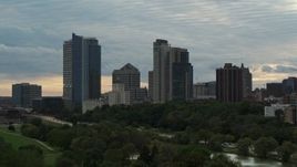5.7K aerial stock footage descend toward park with view of tall skyscrapers in the city's skyline at sunset, Downtown Milwaukee, Wisconsin Aerial Stock Footage | DX0002_155_015