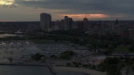 5.7K aerial stock footage of skyscrapers in the city's skyline seen while passing the marina at twilight, Downtown Milwaukee, Wisconsin Aerial Stock Footage | DX0002_155_027