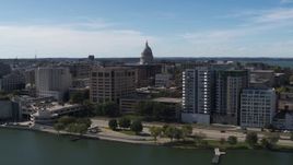 5.7K aerial stock footage descend and fly away from the capitol dome surrounded by office buildings, Madison, Wisconsin Aerial Stock Footage | DX0002_158_029