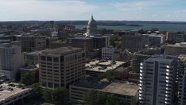 5.7K aerial stock footage of the capitol dome seen while passing office buildings, Madison, Wisconsin Aerial Stock Footage | DX0002_158_038