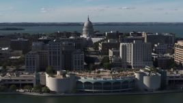5.7K aerial stock footage of the capitol seen while passing by office buildings and convention center, Madison, Wisconsin Aerial Stock Footage | DX0002_160_003