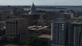 5.7K aerial stock footage fly near office buildings and focus on the capitol building in Madison, Wisconsin Aerial Stock Footage | DX0002_160_019