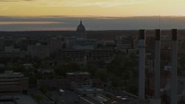 5.7K aerial stock footage focus on the capitol dome at sunset while passing smoke stacks, Madison, Wisconsin Aerial Stock Footage | DX0002_161_027