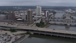 5.7K aerial stock footage reverse view of apartment high-rise and bridges spanning the river, Downtown Cedar Rapids, Iowa Aerial Stock Footage | DX0002_164_011