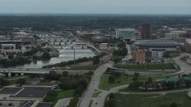 5.7K aerial stock footage of passing by bridges over Cedar River by the arena in Downtown Des Moines, Iowa Aerial Stock Footage | DX0002_167_012
