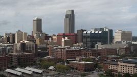 5.7K aerial stock footage reverse view of a towering skyscraper and downtown skyline in Downtown Omaha, Nebraska Aerial Stock Footage | DX0002_168_012
