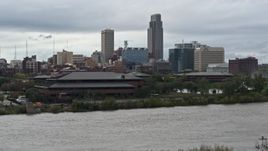5.7K aerial stock footage descend by river and riverfront park with view of skyline, Downtown Omaha, Nebraska Aerial Stock Footage | DX0002_169_021