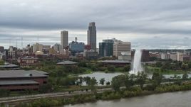 5.7K aerial stock footage flying by a fountain in a park and skyline, Downtown Omaha, Nebraska Aerial Stock Footage | DX0002_169_026