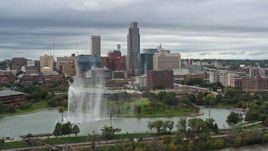 5.7K aerial stock footage of the city's skyline while passing a park fountain, Downtown Omaha, Nebraska Aerial Stock Footage | DX0002_169_031