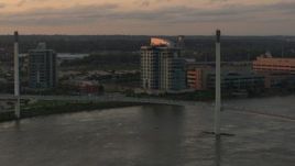 5.7K aerial stock footage orbit condo complex behind a pedestrian bridge spanning the Missouri River at sunset, Omaha, Nebraska Aerial Stock Footage | DX0002_172_028