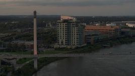 5.7K aerial stock footage of a condo complex near a pedestrian bridge spanning the Missouri River at sunset, Omaha, Nebraska Aerial Stock Footage | DX0002_172_029