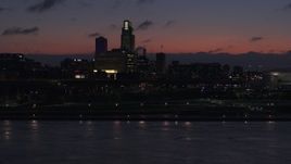 5.7K aerial stock footage descend toward river while focused on the skyline at twilight, Downtown Omaha, Nebraska Aerial Stock Footage | DX0002_173_006