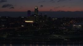 5.7K aerial stock footage of a reverse view of the city's skyline at twilight, reveal the river, Downtown Omaha, Nebraska Aerial Stock Footage | DX0002_173_009