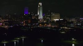 5.7K aerial stock footage of slowly flying away from tall skyscrapers at night, Downtown Omaha, Nebraska Aerial Stock Footage | DX0002_173_049