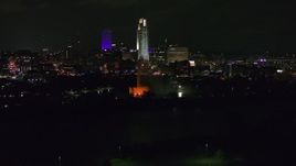 5.7K aerial stock footage of towering skyscrapers behind the fountain lit up at night, Downtown Omaha, Nebraska Aerial Stock Footage | DX0002_173_053
