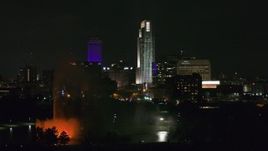 5.7K aerial stock footage flying by skyscrapers and high-rises at night, reveal the park fountain, Downtown Omaha, Nebraska Aerial Stock Footage | DX0002_173_057