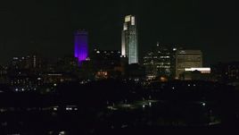 5.7K aerial stock footage descending away from the city's skyscrapers seen from the park at night, Downtown Omaha, Nebraska Aerial Stock Footage | DX0002_173_061