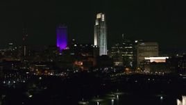 5.7K aerial stock footage ascend toward the city's skyscrapers from the park at night, Downtown Omaha, Nebraska Aerial Stock Footage | DX0002_173_062