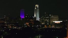 5.7K aerial stock footage fly away from city's skyscrapers, reveal the park fountain at night, Downtown Omaha, Nebraska Aerial Stock Footage | DX0002_173_063