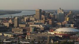 5.7K aerial stock footage of a reverse view of tall office towers and the arena at sunset, Downtown Memphis, Tennessee Aerial Stock Footage | DX0002_181_006