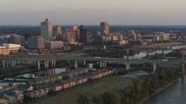 5.7K aerial stock footage of the city's skyline behind the bridge and the river at sunset, Downtown Memphis, Tennessee Aerial Stock Footage | DX0002_181_010
