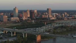 5.7K aerial stock footage of a reverse view of the city's skyline behind the bridge and the river at sunset, Downtown Memphis, Tennessee Aerial Stock Footage | DX0002_181_013
