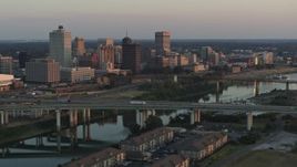 5.7K aerial stock footage a view of the city's skyline behind the bridge and the river at sunset, Downtown Memphis, Tennessee Aerial Stock Footage | DX0002_181_015