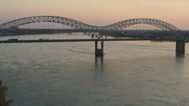 5.7K aerial stock footage flying by traffic crossing the Hernando de Soto Bridge at sunset, Downtown Memphis, Tennessee Aerial Stock Footage | DX0002_181_017