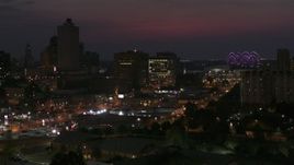 5.7K aerial stock footage of city buildings between office tower and bridge at night, Downtown Memphis, Tennessee, seen during descent Aerial Stock Footage | DX0002_187_028