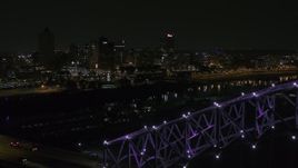 5.7K aerial stock footage of the downtown skyline, reveal the bridge with purple lights at night, Downtown Memphis, Tennessee Aerial Stock Footage | DX0002_187_035
