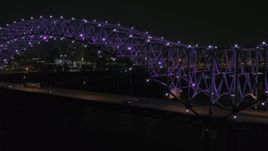 5.7K aerial stock footage of passing the bridge with purple lights and a view of the skyline at night, Downtown Memphis, Tennessee Aerial Stock Footage | DX0002_187_036