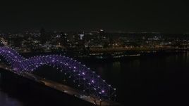 5.7K aerial stock footage ascend past the bridge with purple lights for a view of the skyline at night, Downtown Memphis, Tennessee Aerial Stock Footage | DX0002_187_037