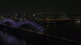 5.7K aerial stock footage flying by the bridge with colorful lights with a view of the skyline at night, Downtown Memphis, Tennessee Aerial Stock Footage | DX0002_187_038