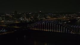 5.7K aerial stock footage of the skyline seen while passing the bridge with colorful lights at night, Downtown Memphis, Tennessee Aerial Stock Footage | DX0002_187_040