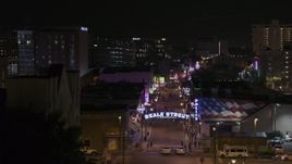 5.7K aerial stock footage of flying by arena to reveal numerous Beale Street clubs and restaurants at nighttime, Downtown Memphis, Tennessee Aerial Stock Footage | DX0002_188_039