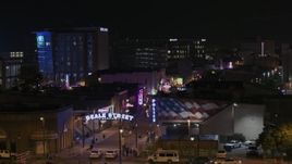 5.7K aerial stock footage of passing the Beale Street sign for view of clubs and restaurants at nighttime, Downtown Memphis, Tennessee Aerial Stock Footage | DX0002_188_040
